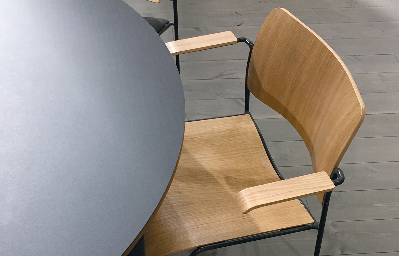 HOWE light wood chair with black metal frame at a modern table